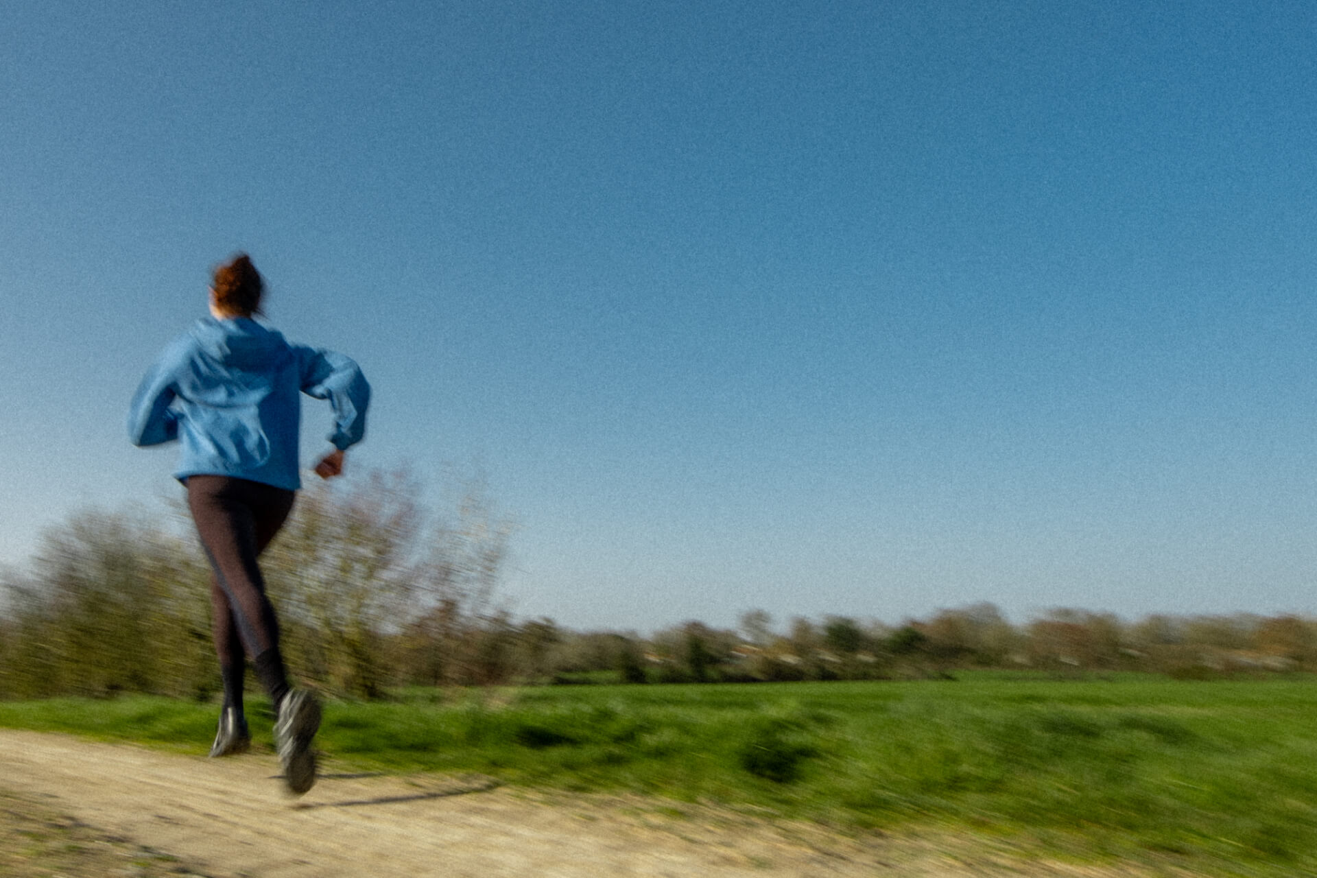 Femme pratiquant le trail running sur une piste lors d’une journée ensoleillée