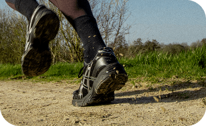 Chaussures de course sur un chemin de terre, foulée talon. Exercice en plein air.