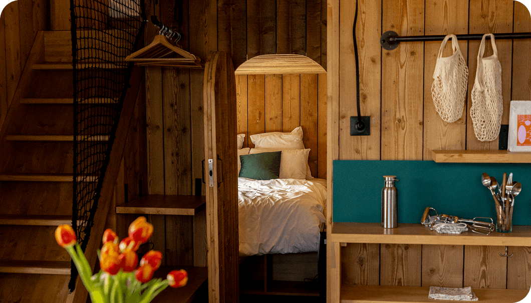 cabanes en bois Intérieur confortable avec lit, escalier et boiseries rustiques.
